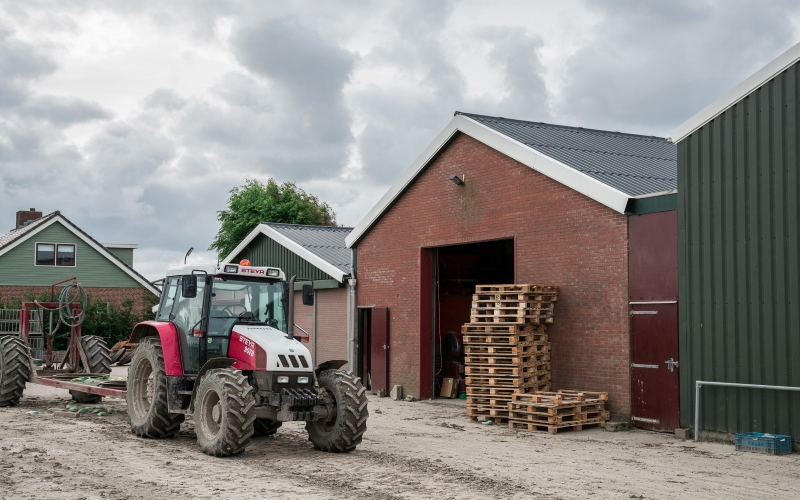Tractor die naast nieuw magazijn rijdt